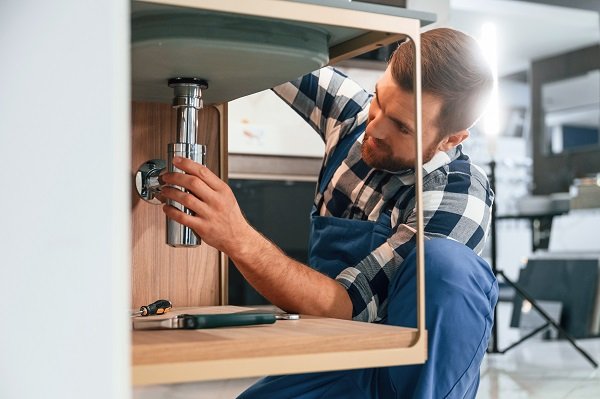 plumber with drain cleaning sink