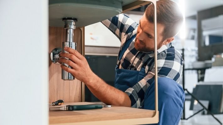 Plumber with drain cleaning sink